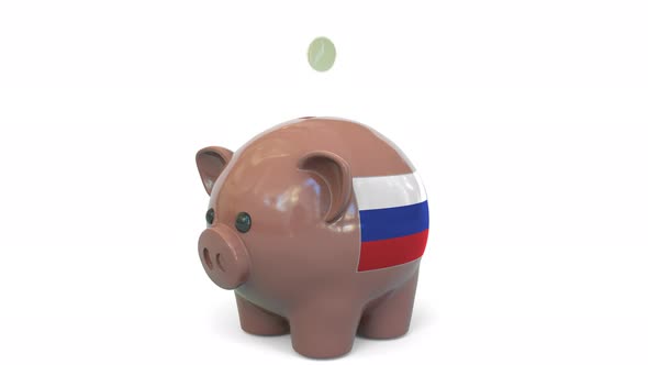 Putting Money Into Piggy Bank with Flag of Russia