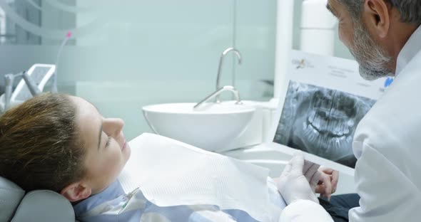 Dentist Showing x Ray Picture To Patient