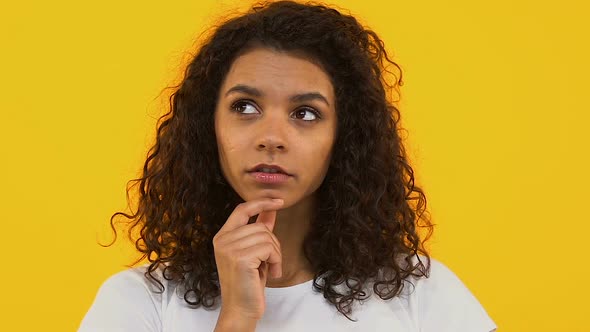 Pensive African Woman on Bright Background Thinking of Choice, Dreaming Person