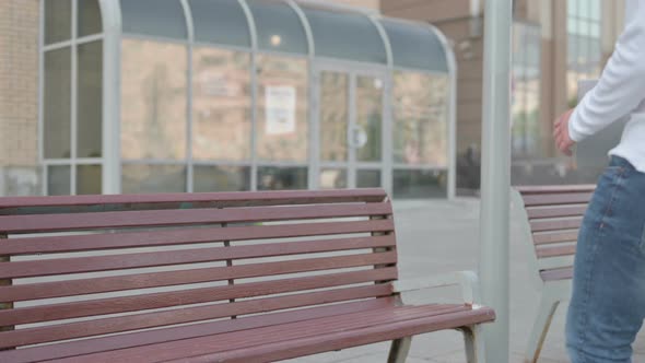 Young Man Coming Sitting on Bench and Opening Laptop