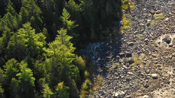 Aerial footage of a remote lake in Northern Maine after a dry summer ORBIT around rocky shoreline CL