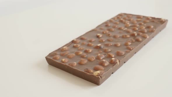 Tilting on  opened milk chocolate with whole hazelnuts close-up 4K 2160p 30fps UltraHD tilting foota