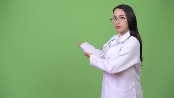 Young Beautiful Asian Woman Doctor Showing Something