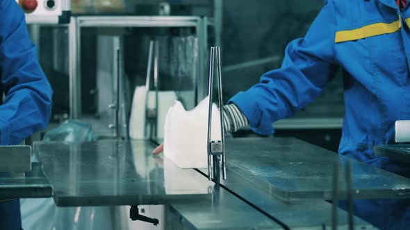 Factory Workers Placing Stacks of White Facial Tissues on a Conveyor