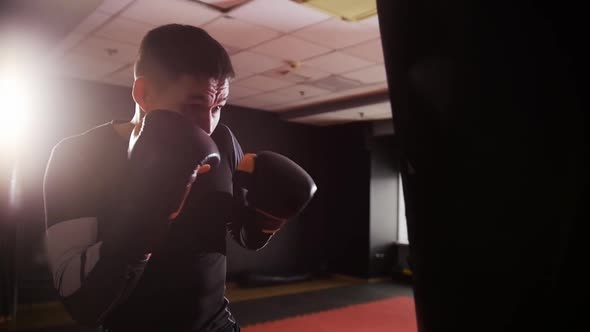 Box Training  Fit Man Punching the Punching Bag in Slow Motion