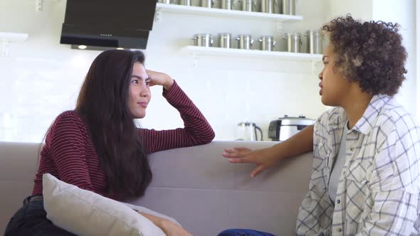 Two Girlfriends Gossiping While Sitting on the Couch