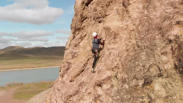 Man Athlette Climbing on the High Rock