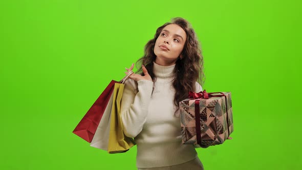 The Woman is Holding a Gift and Shopping Bags