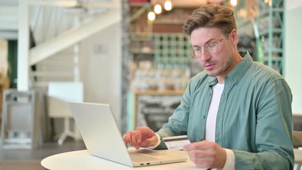 Online Payment Success on Laptop By Middle Aged Man in Cafe 