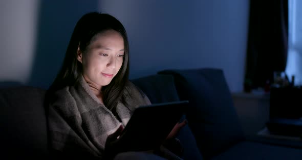 Woman use of tablet computer at night