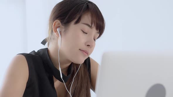 Young asian woman smiling say hello using chat social network with video call on laptop computer.