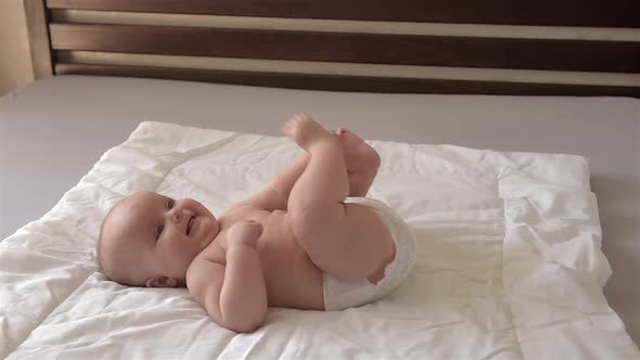 Cute Baby Lies on His Back and Moves His Arms and Legs