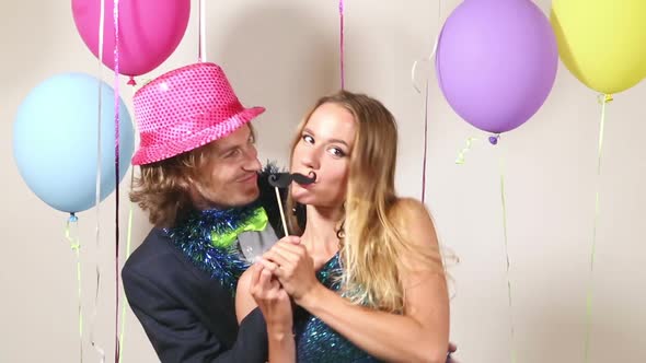 Lovely couple dancing with props in photo booth