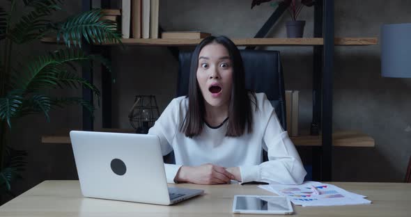 Surprised Asian Business Woman Looks at the Camera in Surprise and Says Wow While Sitting in the