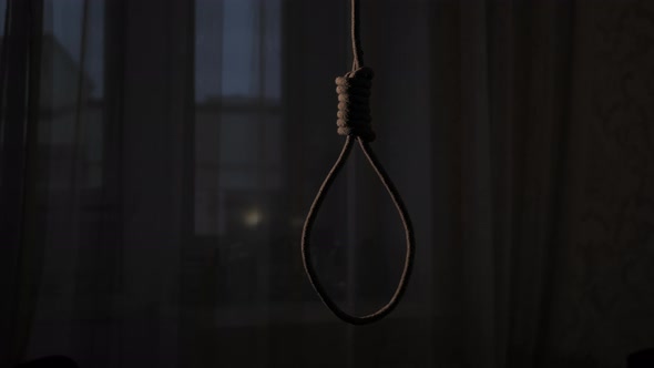 A Rope Noose Hangs in a Dark Apartment