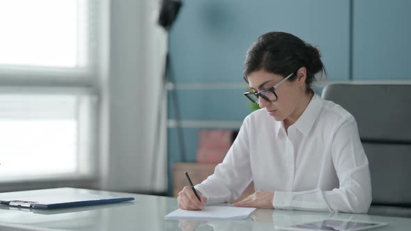 Indian Businesswoman Writing on Paper in Office