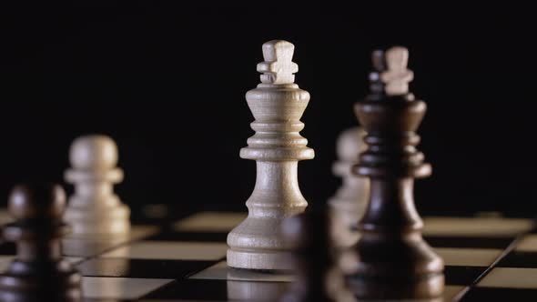 Black and White Chess Kings Rotating on Wooden Board