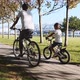 Mother and daughter is riding a bike along the seafront together, steadicam shot - VideoHive Item for Sale