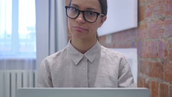 Shaking Head to No by Hispanic Woman Sitting in Office