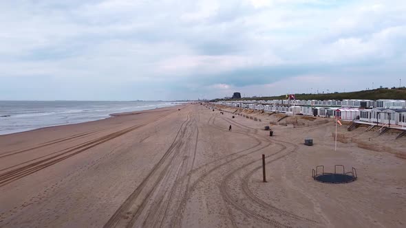 Drone shot of North sea beach with cabins on the right.