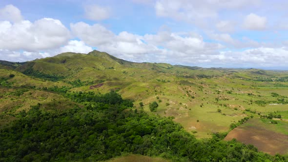 Hills with Green Grass and Blue Sky with White Puffy Clouds