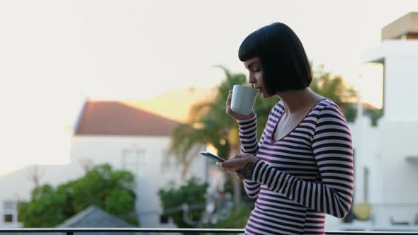 Woman Having Coffee While Using Mobile Phone in The Balcony 4k