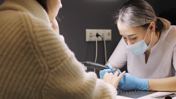 Hardware Manicure Master Is Removing the Gel Coating From the Woman's Nails