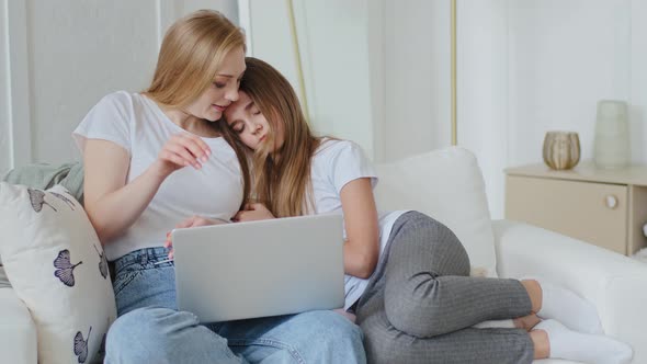 Mature Adult Mother Looks at Laptop Browses Network Little Teenage Daughter Feels Tired Falls Asleep