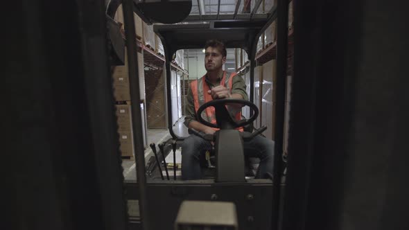 Worker operating forklift truck