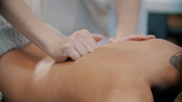 Massage - with Her Fist the Massage Therapist Is Massaging the Back