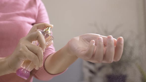 Woman using perfume on her wrist to taste the fragrance.