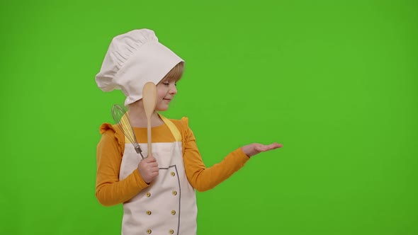 Child Girl Dressed Like Chef Cook Pointing at Right on Blank Space Place for Your Advertisement Logo
