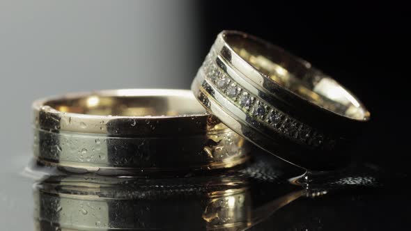 Wedding Rings on Black and White Water Surface Shining with Light