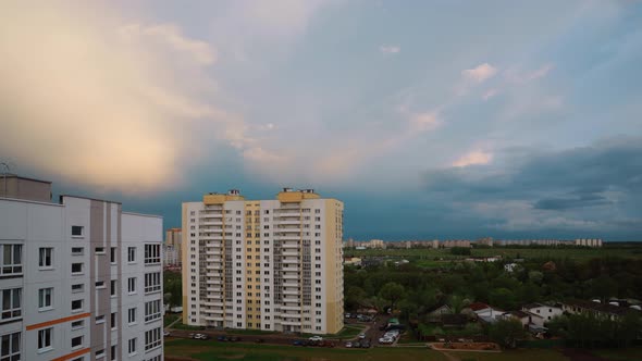 Cloudy Rainy Sky With Fluffy Rain Clouds In Motion Above Multistorey Residential Houses