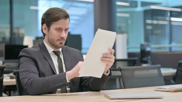 Businessman Reading Documents in Office Paperwork