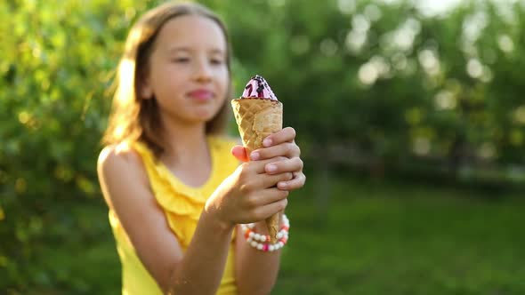 Cute girl with braces eating italian ice cream cone smiling while resting