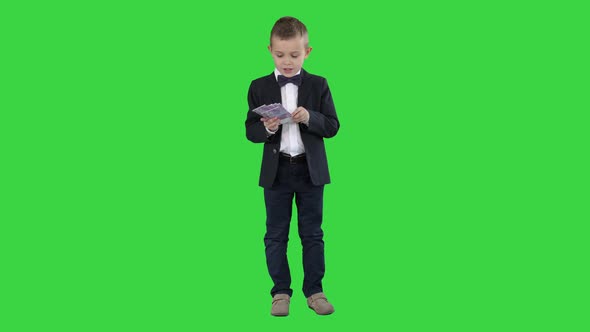 Little Boy in a Suit Counting Money on a Green Screen, Chroma Key.