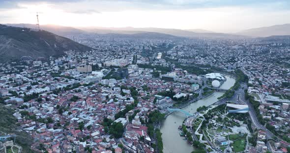 Aerial view of center of Tbilisi under Mtatsminda mountain at sunset. Georgia 2022 summer