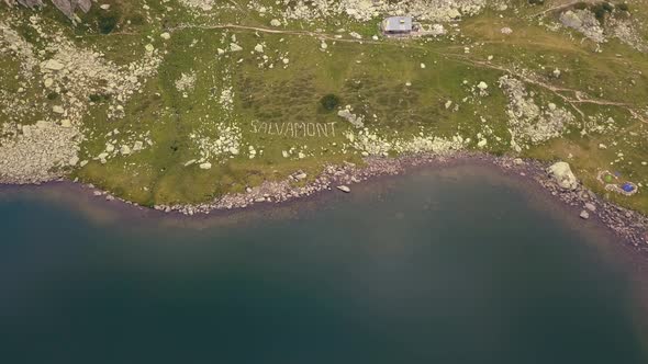 Flying over a beautiful mountain lake, with trails all around.