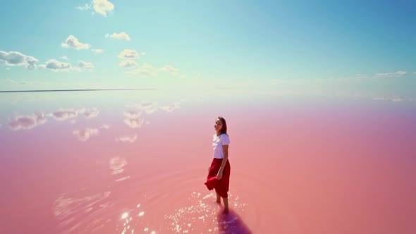 Slow Motion of Woman Traveler Standing Inpink Water with Beautiful Mirror Reflection of Blue Sky on