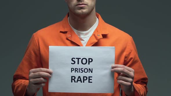 Stop Prison Rape Phrase on Cardboard in Hands of Caucasian Prisoner, Violence