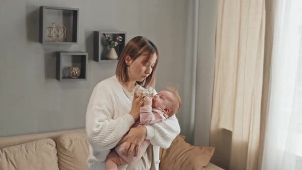 Mom Giving Bottle to Crying Baby