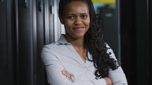 African american female computer technician with security pass in business server room