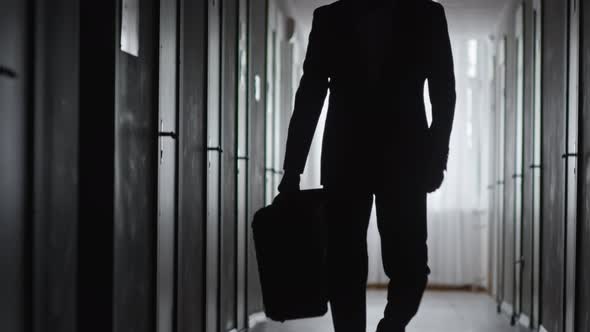 Silhouette of Businessman with Suitcase Walking