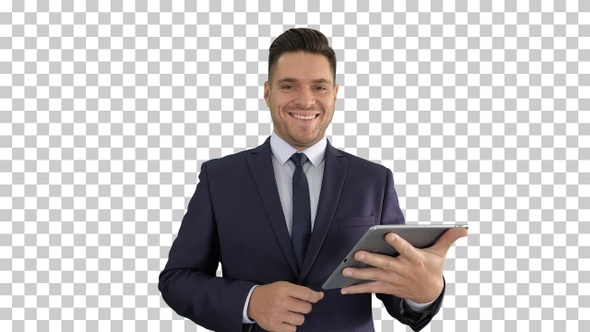 Handsome man swiping pages on tablet and smiling to camera