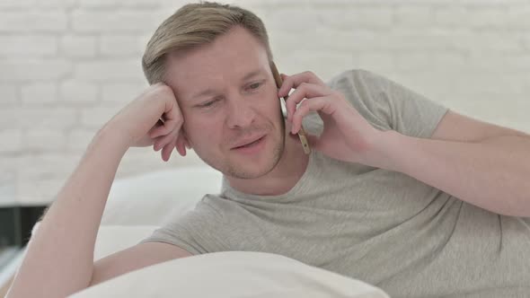 Man Speaking on The Phone While in Bed