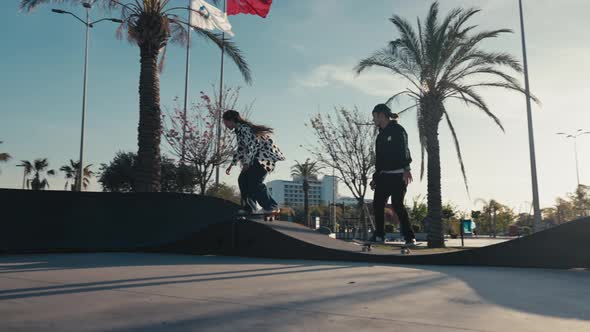 Young Couple Skateboarding at Pump Track or Skate Park on Modern Style