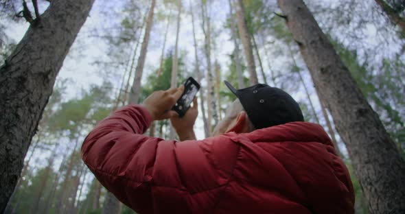 Urban Nomad Hipster Man Film on Phone in Forest