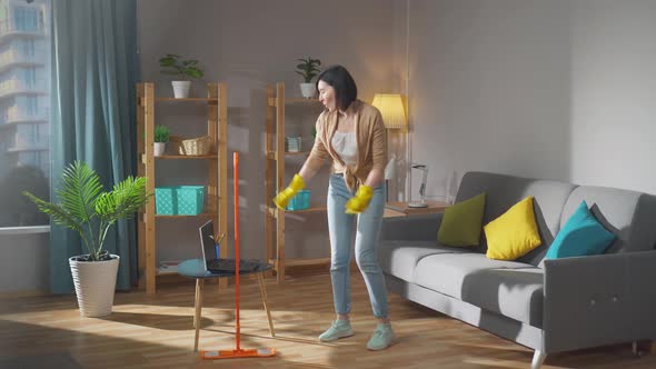 Positive Young Woman Housewife Does the Cleaning and Dancing