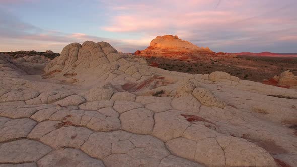 Rising view of desert terrain with drone at sunrise